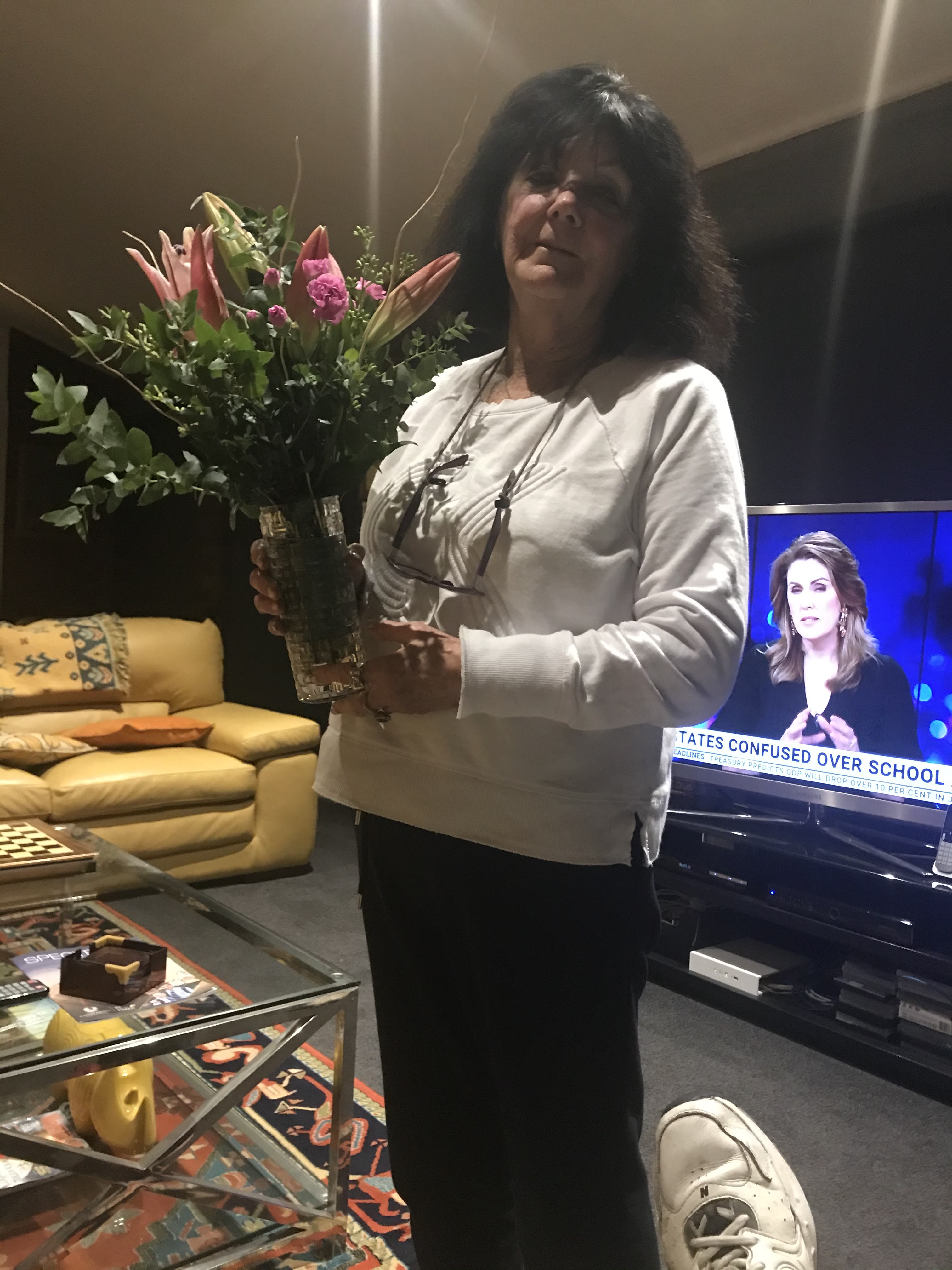 Pam indoors with a bouquet of flowers