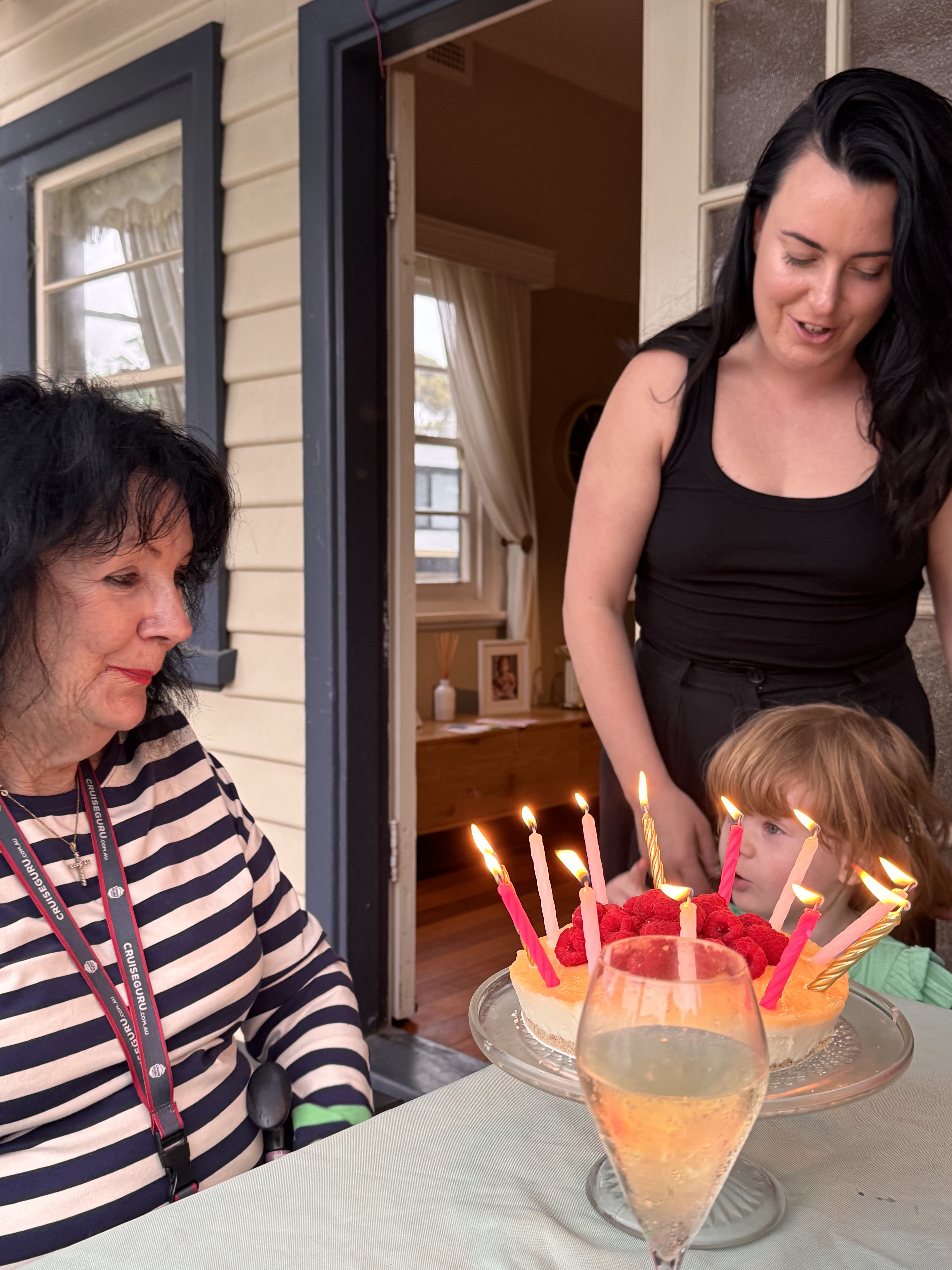 Pam with her granddaughter Holly beside a cake with candles