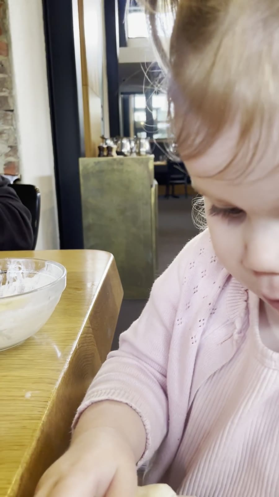 A frame from a family meal video, with a child and relatives around the table