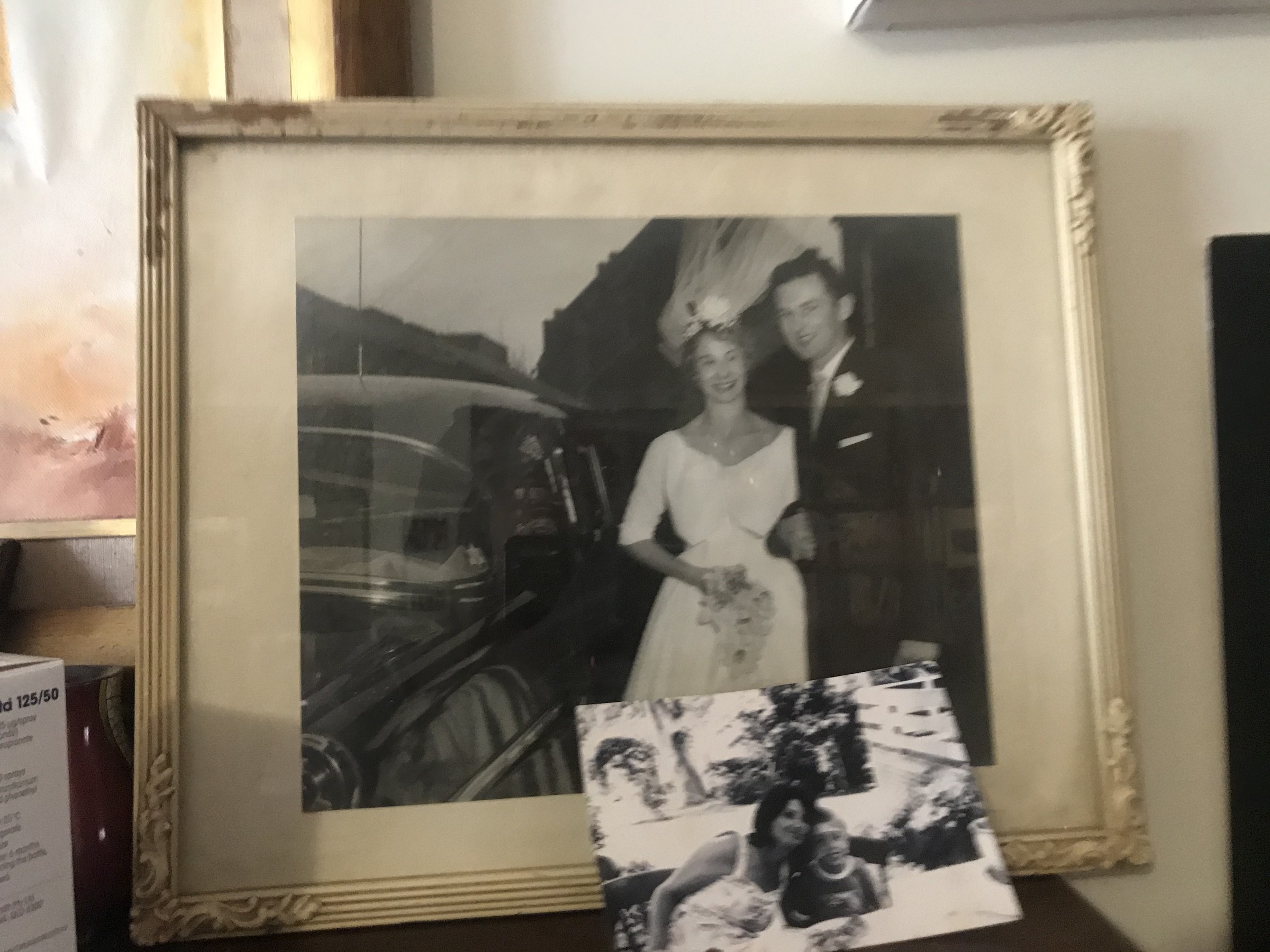 A wedding photograph beside a car, displayed in a frame at Ian’s home