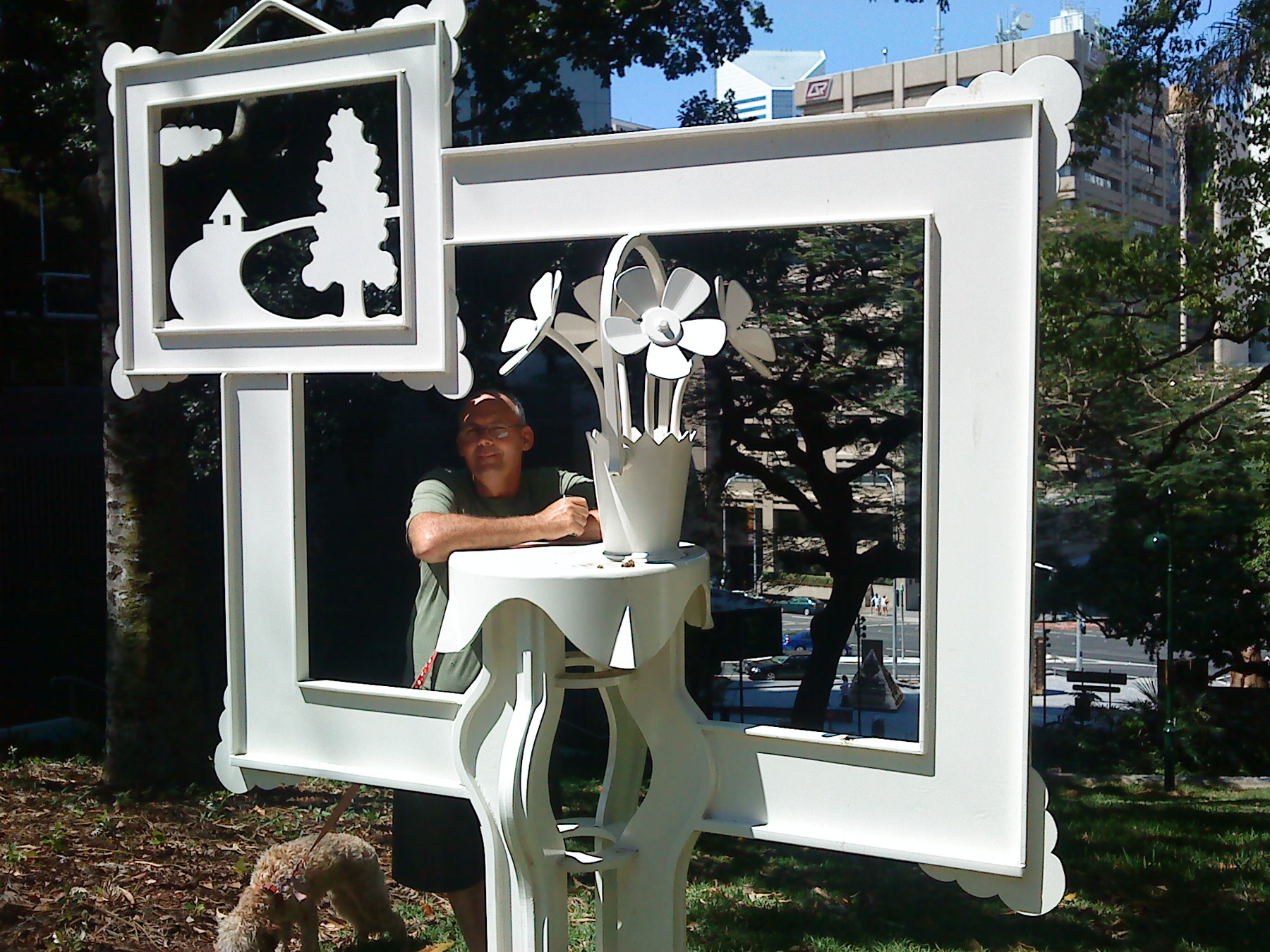 Martin behind an outdoor white sculpture, with a dog in the foreground