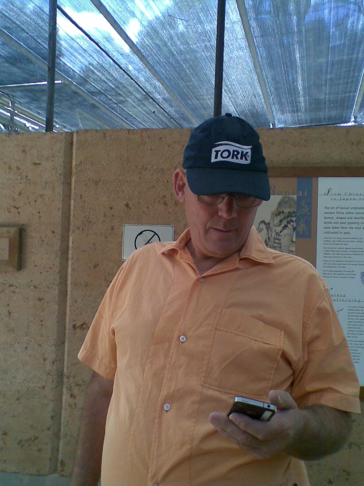 Martin checking a phone beneath a covered roof