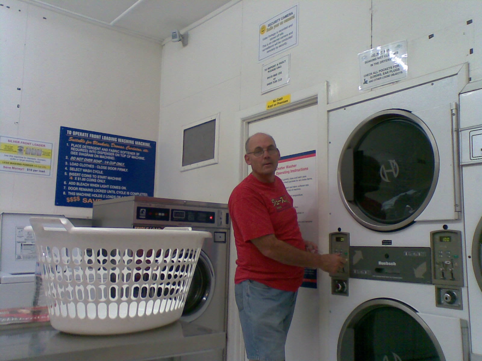 Martin beside front-loading washing machines with a laundry basket