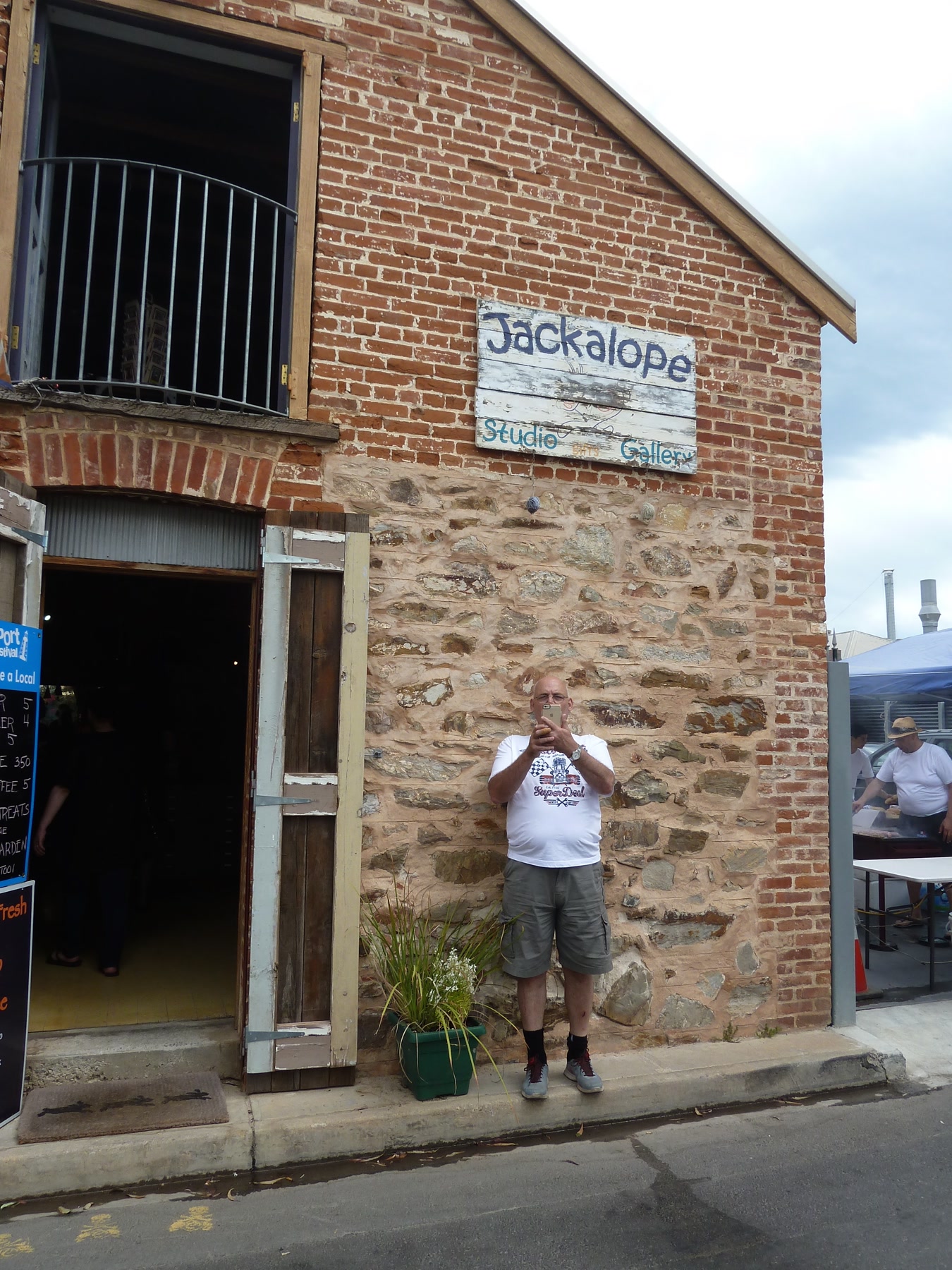 Full-length portrait of Martin outside a brick building signed Jackalope Studio and Gallery