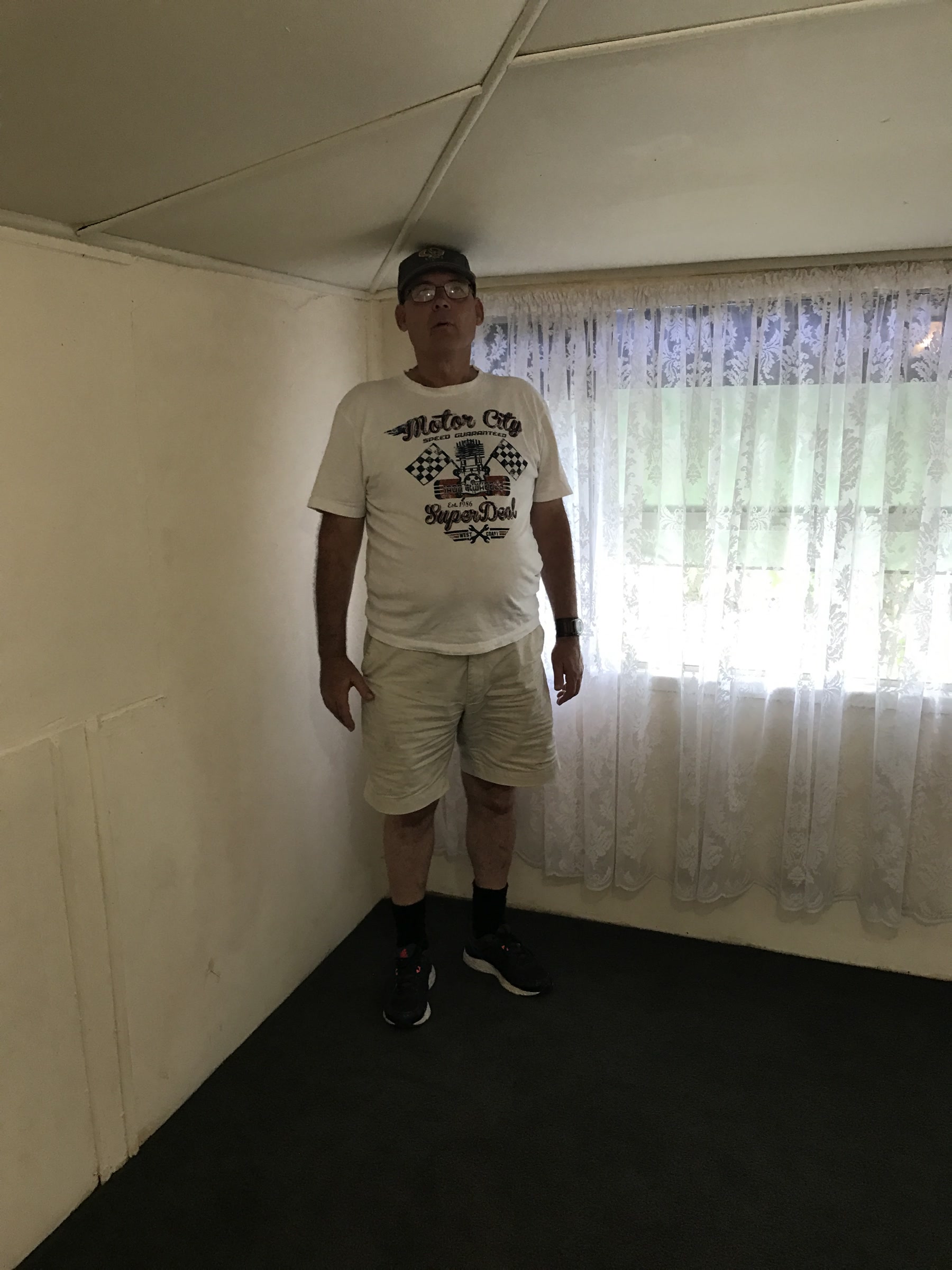 Full-length portrait of Martin standing indoors in a T-shirt and shorts