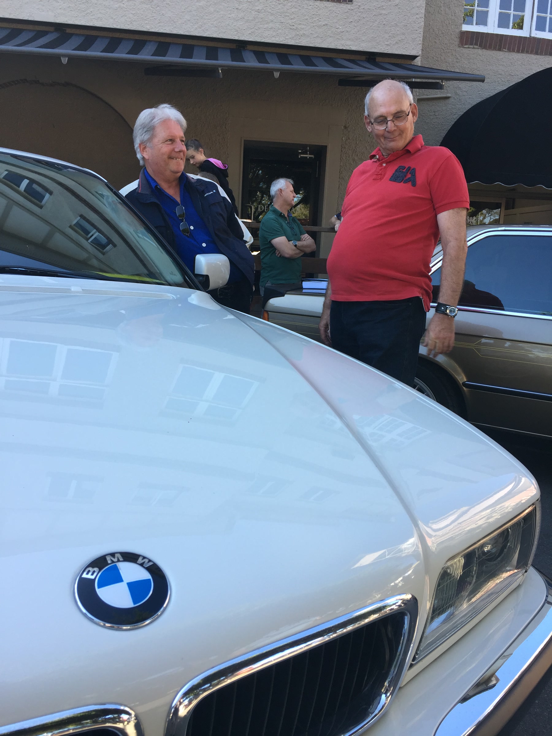 Martin and an unidentified man beside two cars