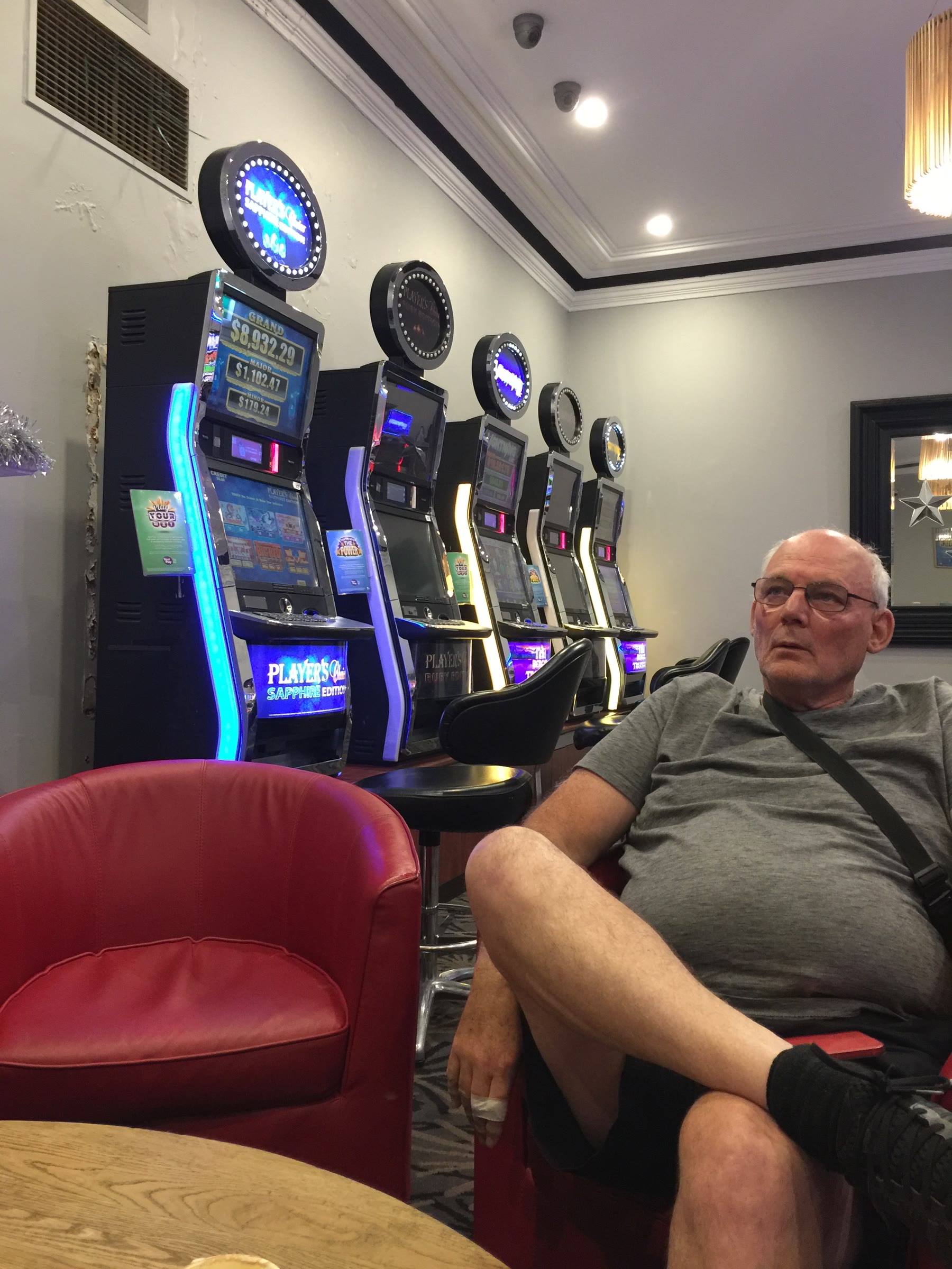 Martin seated beside electronic gaming machines