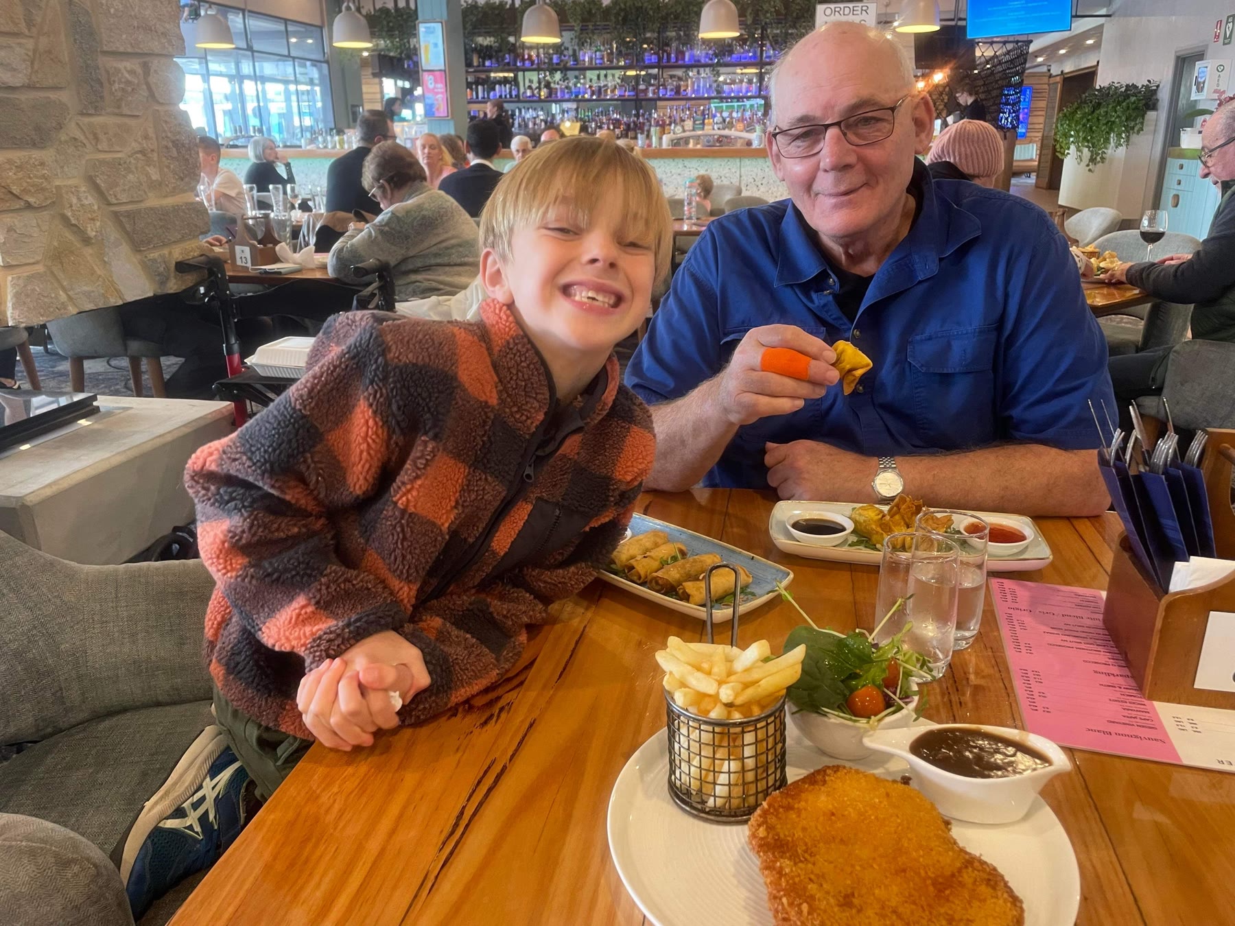 Martin and Olly at a restaurant table with another adult