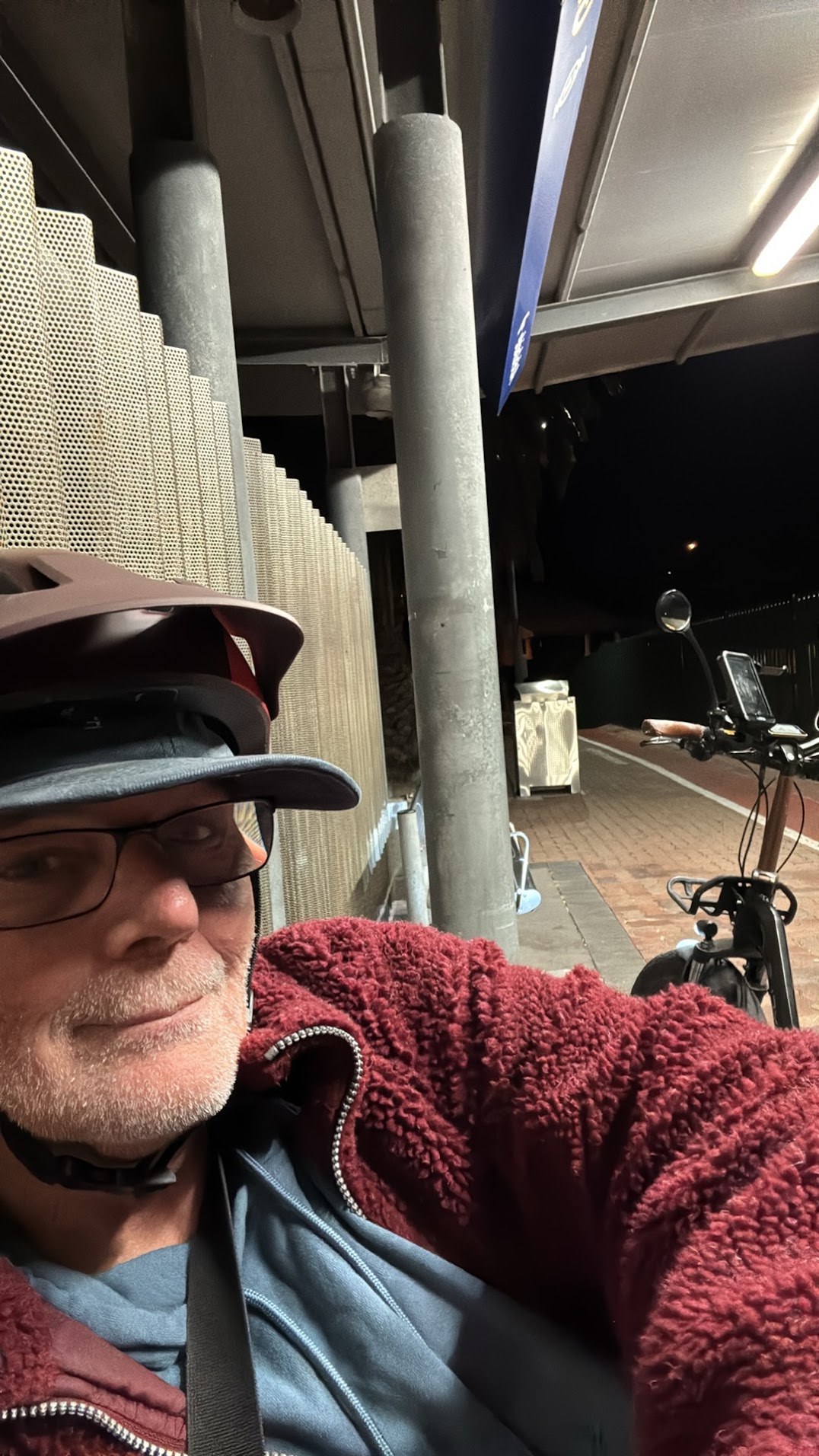 Martin in a late-night portrait beside a bicycle under a covered walkway